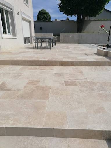 Réalisation d’une terrasse extérieure en travertin de 90 m2, pose multiformat big opus sur la commune de Pusignan